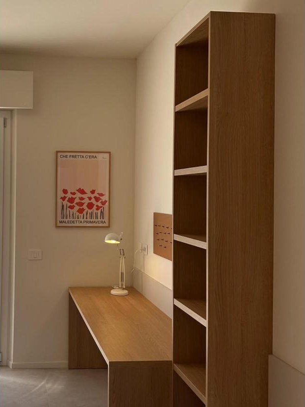 Camera con scrivania e libreria in legno