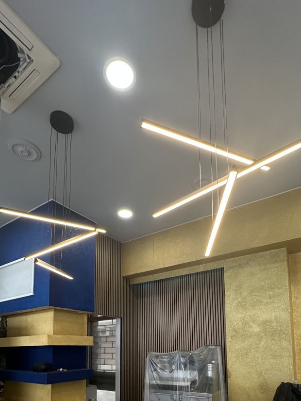 Sala del bar con lampade a sospensione e pareti oro e blu